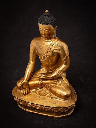 Nepali bronze Buddha statue photographed from above, seated on lotus base