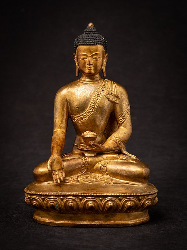 Nepali gilded bronze Buddha statue seated in varada mudra, full front view on lotus base