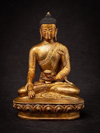 Nepali gilded bronze Buddha statue seated in varada mudra, full front view on lotus base