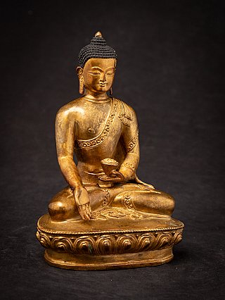Nepali gilded bronze Buddha statue seated with bowl, three-quarter right view