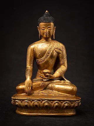 Nepali bronze Buddha statue seated on a lotus base, full front view in bhumisparsha mudra