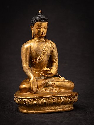 Nepali bronze Buddha statue, three-quarter view with the right hand reaching down in bhumisparsha mudra
