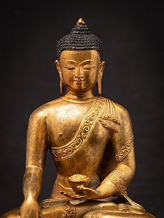 Face and chest detail of the bronze Buddha, front view with the bowl held in the hand