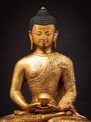 Close-up of the Nepali Buddha statue face and chest with inlaid robe border