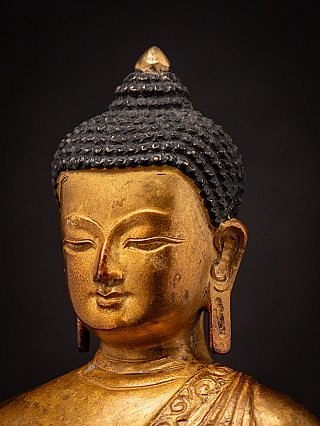 Three-quarter left face detail of a Nepali bronze Buddha statue