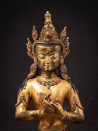 Close-up of the face and crown of the Nepali bronze Buddha, frontal view