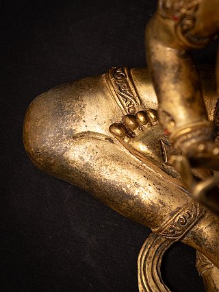 Detail of folded leg with toes and border ornament on the Nepali bronze Buddha