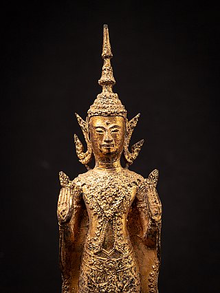 Face and crown detail of a Thai bronze Buddha statue, frontal close-up