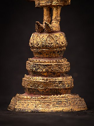 Tiered base detail of a Thai bronze Buddha statue with worn gilded surface