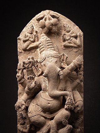 Close-up of Ganesha on the sandstone relief panel, showing trunk, multiple arms and arch decoration
