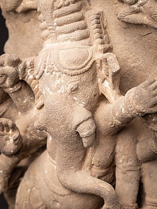Detail of Ganesha’s head and trunk on the relief panel, with arm and background to the right