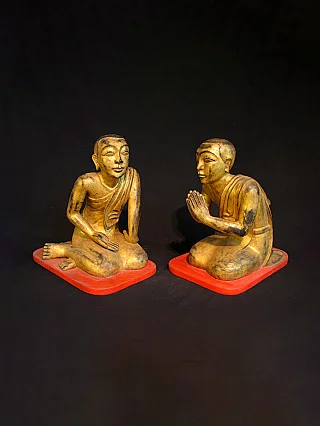 Set of 19th-century wooden monk statues from Burma (Myanmar) on red bases, angled view