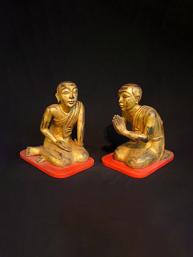 Set of 19th-century wooden monk statues from Burma (Myanmar) on red bases, angled view