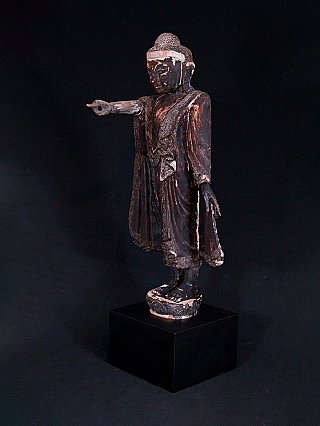 Burmese Mandalay Buddha statue in wood, three-quarter view with extended pointing arm