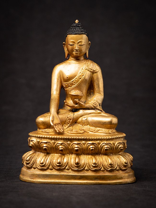Nepali bronze Buddha statue seated on a lotus base, full-front view with varada mudra