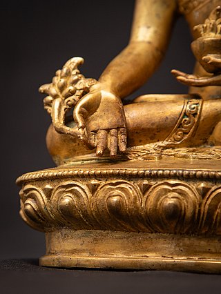 Detail van hand, knie en lotussokkel van de Nepalese bronzen Medicijnboeddha