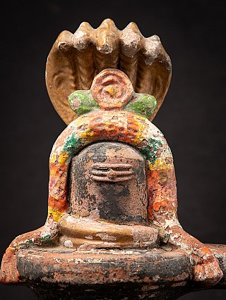 Close-up of the terracotta Shiva lingam showing the polychrome arch framing the lingam
