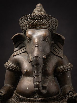 Bronze Ganesha head close-up, front view with trunk and textured headdress