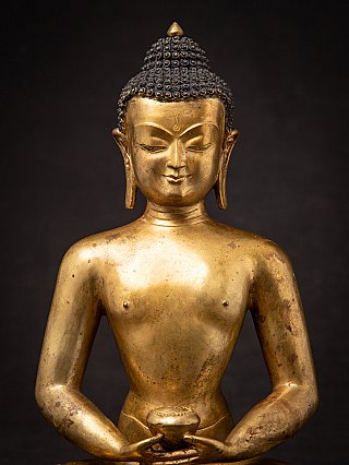 Frontal upper-body detail of a Nepali gilded bronze Buddha statue with serene face
