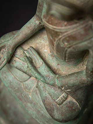Detail of the hand resting in the lap and robe surface with green patina