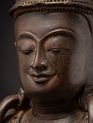 Close-up of the bronze Buddha face with closed eyes and subtle smile