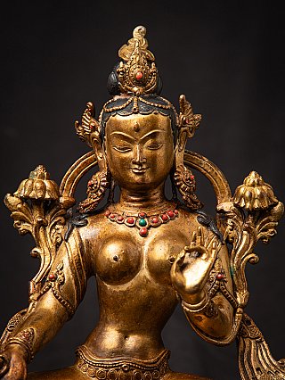 Green Tara bronze statue detail showing face and chest with crown and coloured inlay