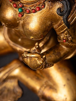 Detail of the hand near the torso with bracelet and necklace showing red and green inlay
