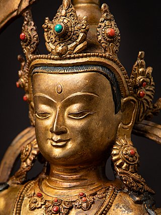 Close-up face detail of a Nepali bronze Manjushri statue with jewellery