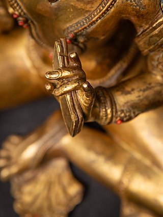 Detail of the hand holding a book, fingers forming vitarka mudra on the Manjushri statue