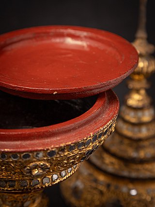 Detail of the open rim with red lacquered lid hovering above, gilded exterior