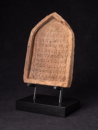 Votieftablet uit Myanmar met reliëf, driekwartaanzicht op zwarte sokkel