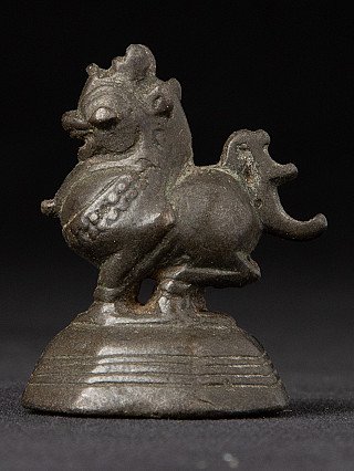 Bronzen opiumgewicht uit Birma (Myanmar), dierfiguur op geribbelde sokkel in driekwartaanzicht