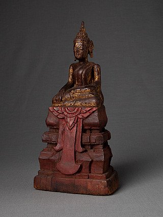 Wooden Buddha statue from Thailand with traces of gilding and red base, three-quarter left view