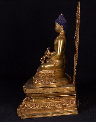 Geneeskundeboeddhabeeld in brons uit Nepal, zittend zijaanzicht met lotus- en voetstukdetails