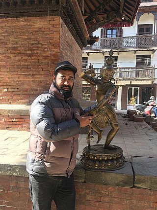 Große Bodhisattva-Bronzestatue aus Nepal neben einer Person als Größenvergleich, Gesamtansicht