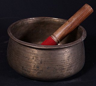 Nepali bronze singing bowl (19th century) with wooden striker resting inside
