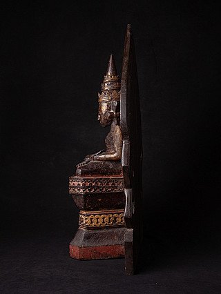 Seated wooden Mon Buddha statue in side profile with tall crown and flat back panel