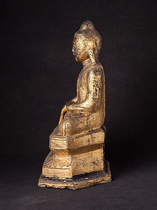 Antique Burmese Buddha statue in lacquerware, left side profile showing seated silhouette