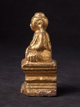 Myanmar wooden Buddha statue seated on a stepped base, side profile view