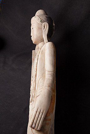 Side profile detail of the reclining marble Buddha statue head and arm