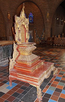 Antique Burmese wooden throne from Myanmar, three-quarter left view showing red lacquer and gilding