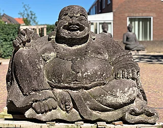 Large lavastone Happy Buddha statue from Indonesia, seated, full-front view outdoors