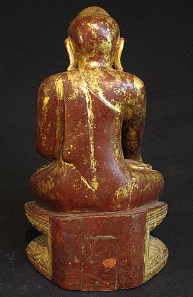Rear view of the wooden Shan Buddha statue with red lacquer and worn gilding