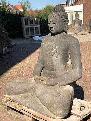 Indonesian lavastone Buddha statue in three-quarter view, seated with hands in dhyana mudra