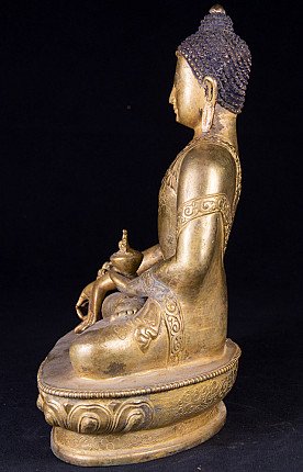 Medizin-Buddha-Statue aus Nepal in Bronze, linke Seitenansicht mit Gewand und Sockelrand