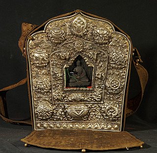 Large old Nepali gao, front view with embossed metal cover and window showing a small statue