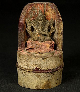 Nepalese bronze Ganesha statue on bamboo, full front view in a niche with red pigment traces