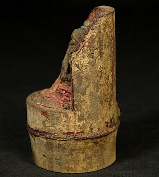 Bamboo base with niche and bronze Ganesha statue, side view showing worn surface and paint remnants