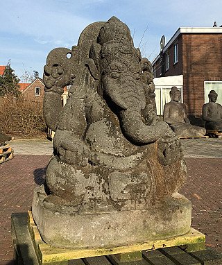Ganesha-Statue aus Lavastein in Dreiviertelansicht, Rüssel über dem Arm, sitzend