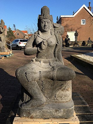 Large Devi Tara statue in Indonesian lavastone, seated full front view outdoors on a pallet